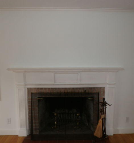 Fireplace with white surround and mantle with tools